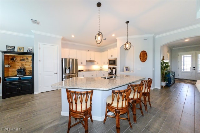 kitchen featuring hanging light fixtures, white cabinetry, appliances with stainless steel finishes, and sink