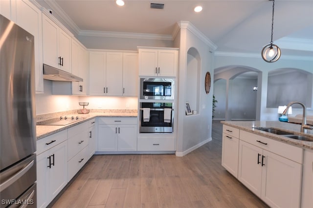 kitchen with white cabinetry, appliances with stainless steel finishes, sink, and light stone counters