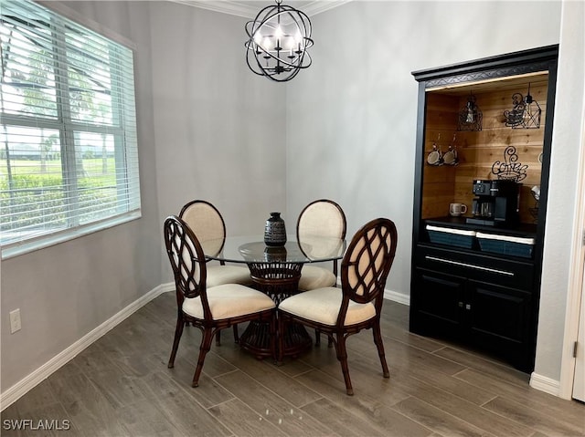 dining area featuring crown molding, hardwood / wood-style floors, and a chandelier