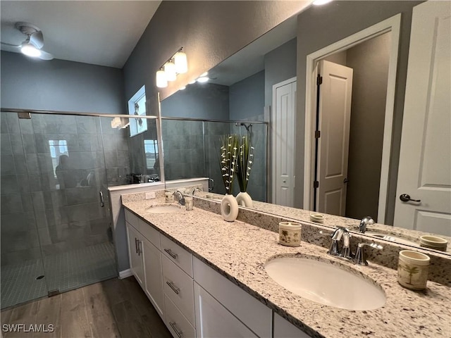 bathroom with wood-type flooring, an enclosed shower, and vanity