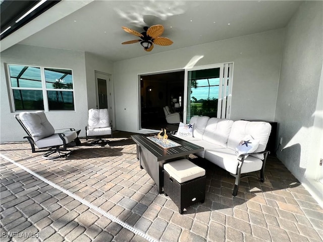 view of patio / terrace featuring ceiling fan and an outdoor living space with a fire pit