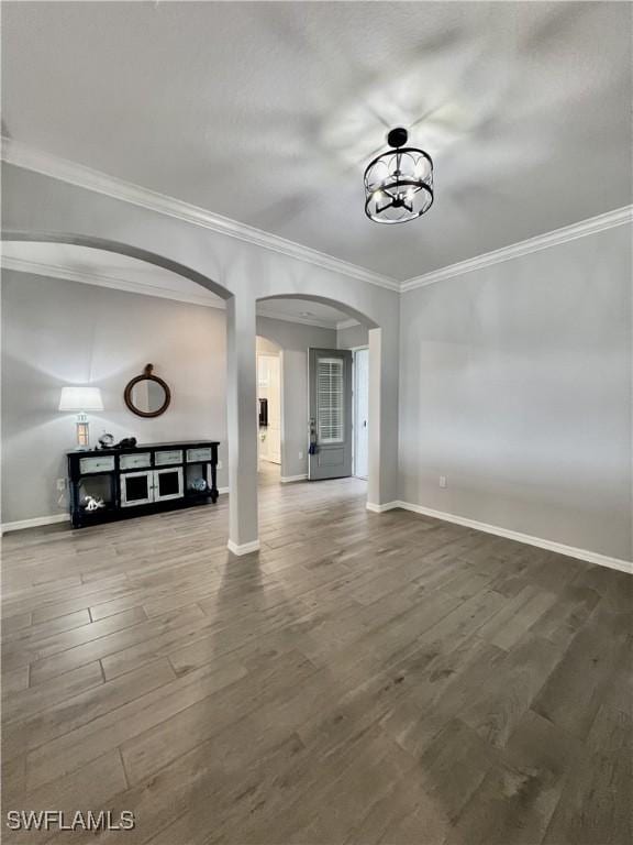 interior space featuring an inviting chandelier, ornamental molding, and hardwood / wood-style floors