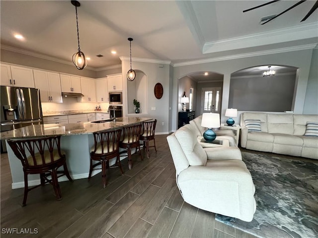 living room with ornamental molding, sink, and a chandelier