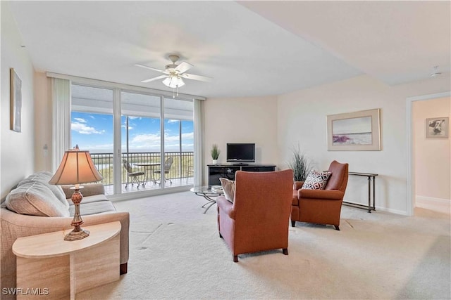 living room with floor to ceiling windows, ceiling fan, and light colored carpet