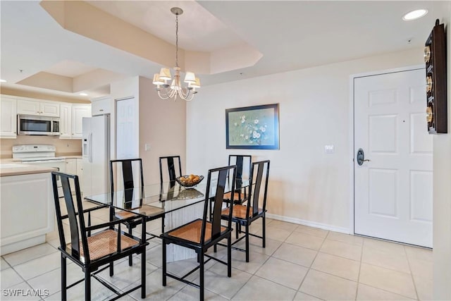 dining room featuring a raised ceiling, light tile patterned floors, and a notable chandelier