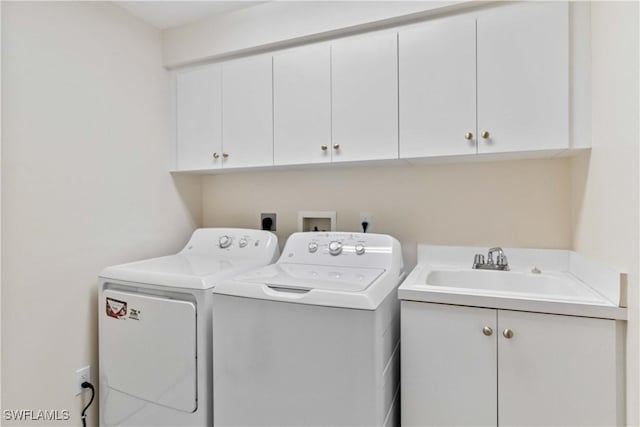 laundry room with independent washer and dryer, cabinets, and sink