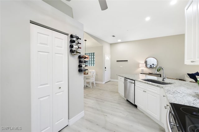 kitchen with white cabinets, sink, light wood-type flooring, light stone counters, and stainless steel appliances