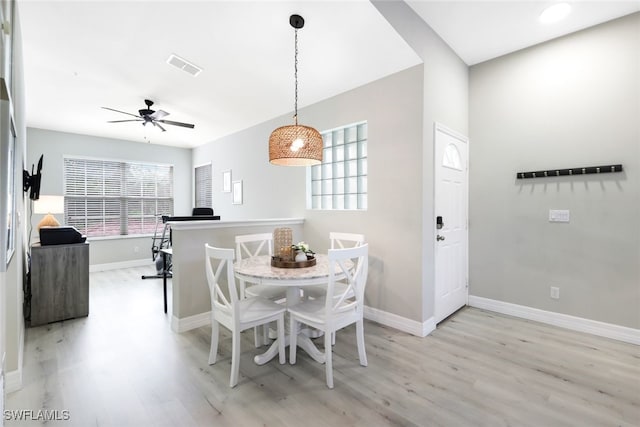 dining area with light wood-type flooring and ceiling fan