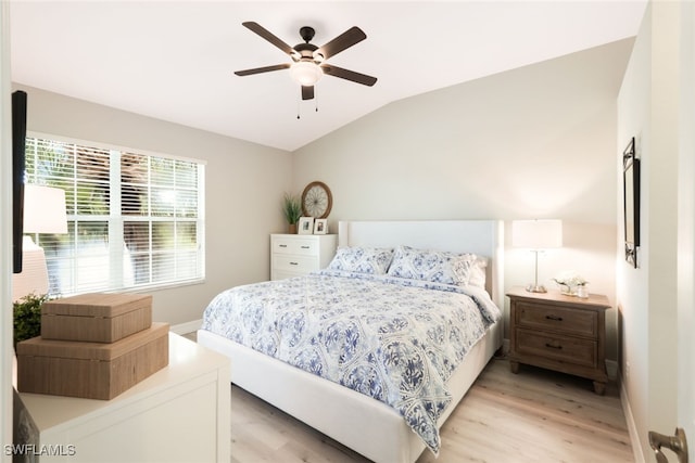 bedroom with ceiling fan, lofted ceiling, and light wood-type flooring