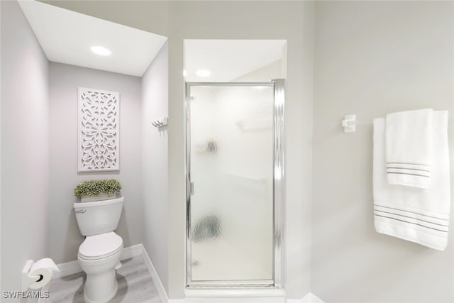 bathroom featuring wood-type flooring, toilet, and an enclosed shower