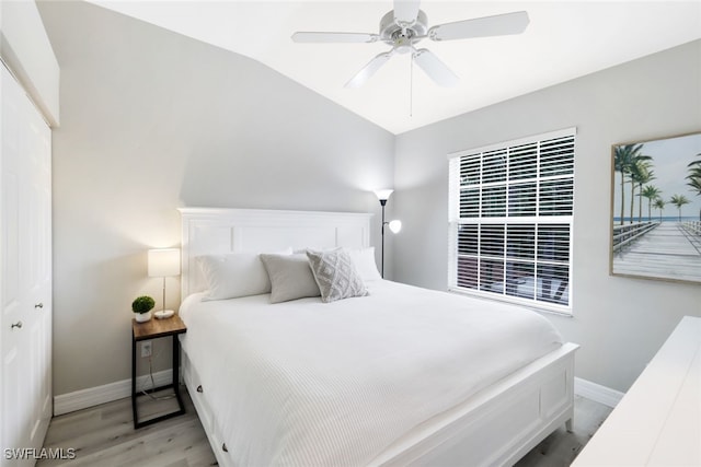 bedroom featuring light wood-type flooring, a closet, lofted ceiling, and ceiling fan