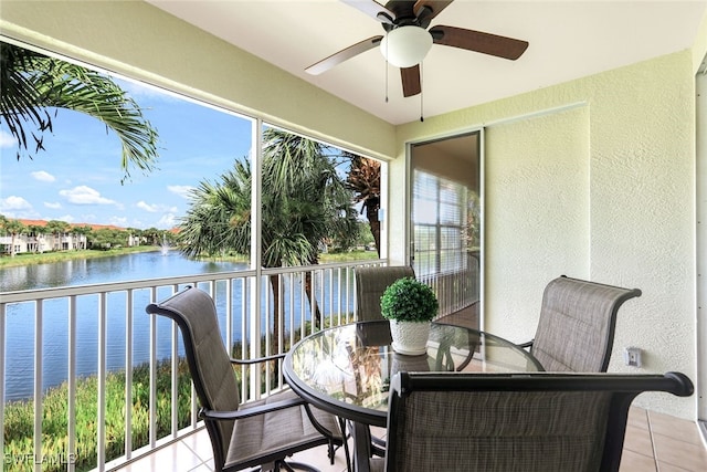 sunroom / solarium with ceiling fan and a water view