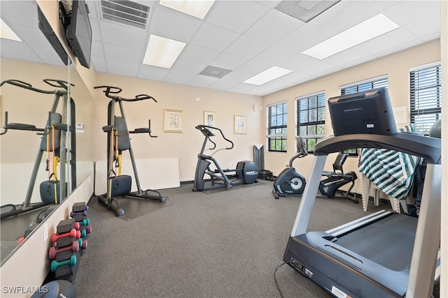 exercise room with a paneled ceiling and plenty of natural light