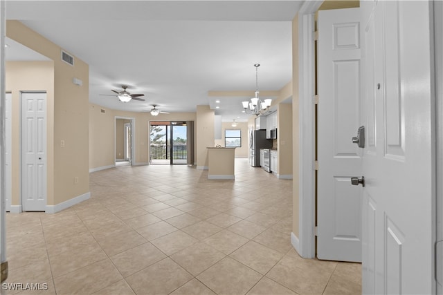 empty room featuring light tile patterned floors and ceiling fan with notable chandelier