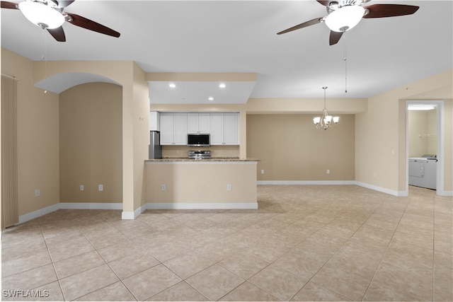 kitchen with stainless steel appliances, light stone counters, washer / dryer, white cabinets, and ceiling fan with notable chandelier