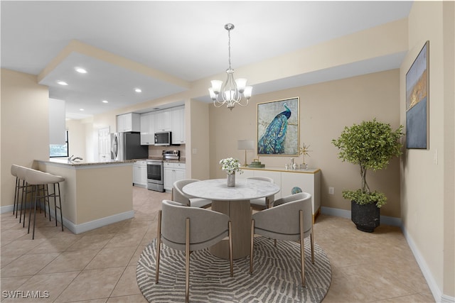 tiled dining room featuring an inviting chandelier