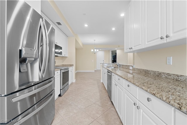 kitchen featuring decorative light fixtures, a notable chandelier, light tile patterned flooring, white cabinetry, and stainless steel appliances