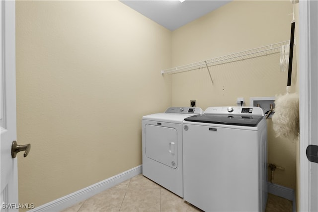 laundry area featuring washing machine and dryer and light tile patterned flooring