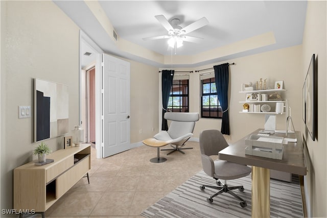 tiled home office with a raised ceiling and ceiling fan