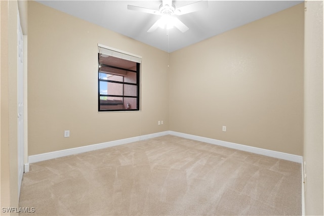 spare room featuring light carpet and ceiling fan