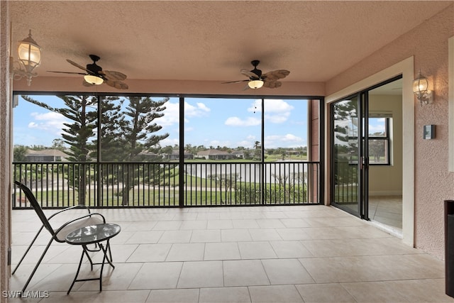 unfurnished sunroom featuring ceiling fan