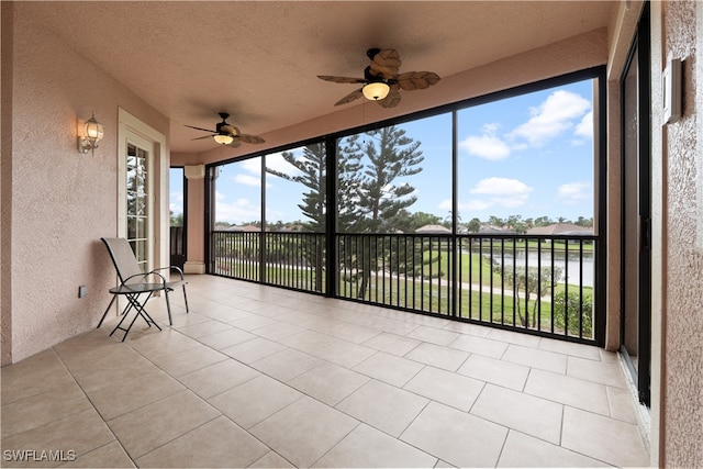 unfurnished sunroom with ceiling fan