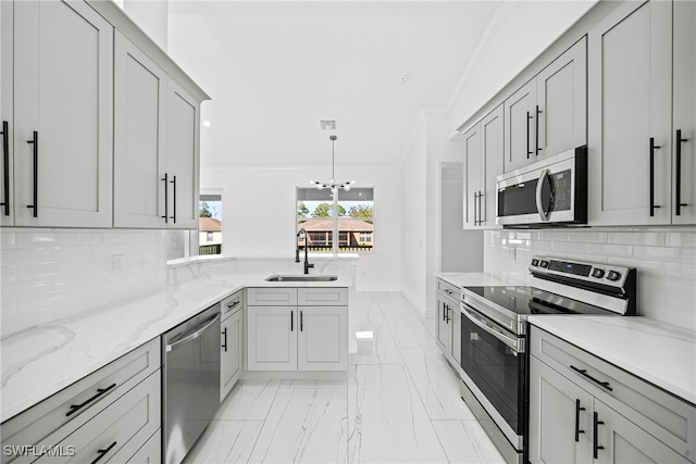 kitchen featuring appliances with stainless steel finishes, decorative light fixtures, gray cabinetry, and sink