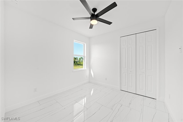 unfurnished bedroom with ceiling fan and a closet