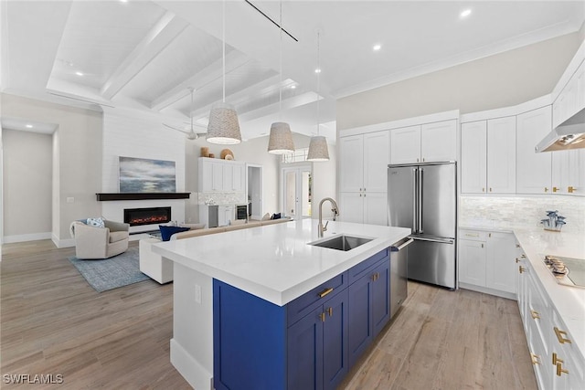 kitchen with light countertops, appliances with stainless steel finishes, white cabinetry, a sink, and blue cabinets