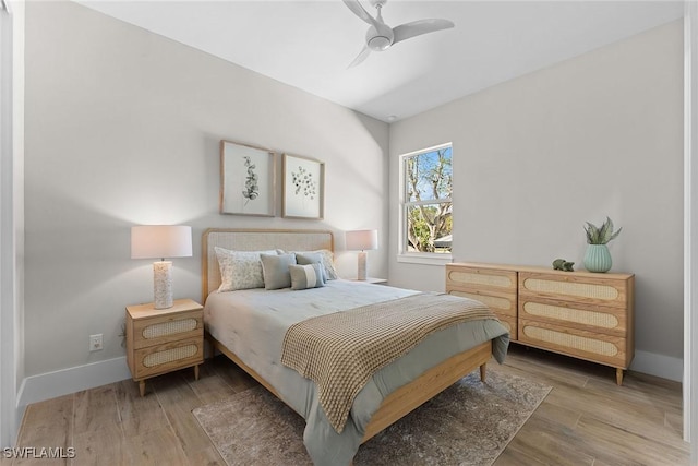 bedroom with ceiling fan, baseboards, and wood finished floors