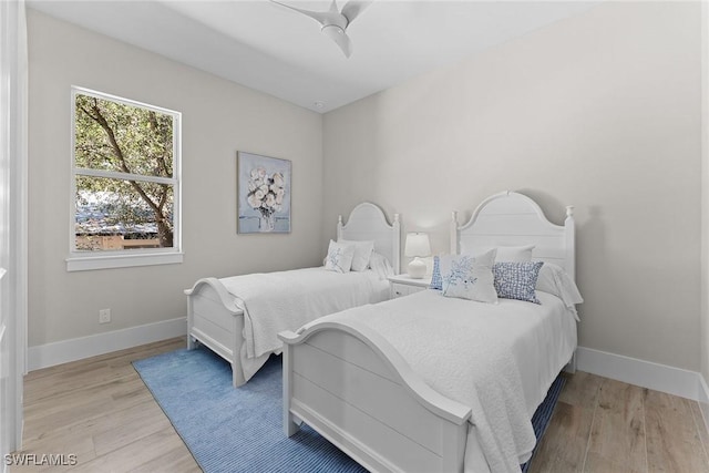 bedroom featuring baseboards, ceiling fan, and light wood-style floors