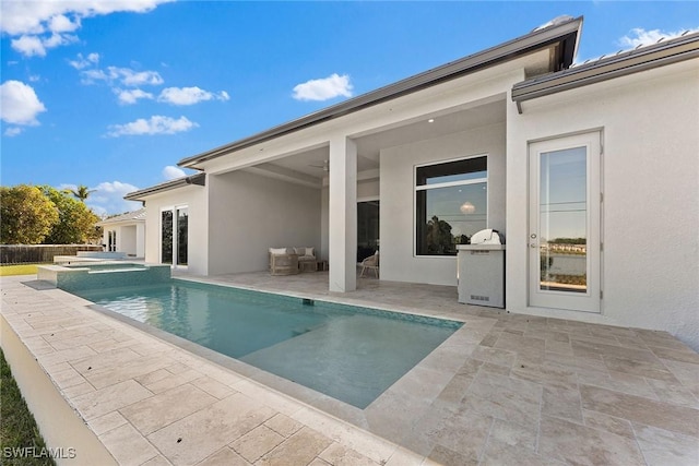 view of swimming pool featuring a pool with connected hot tub and a patio