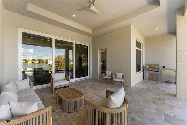 view of patio featuring ceiling fan, a grill, an outdoor kitchen, and an outdoor living space