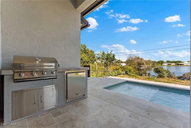 outdoor pool with a water view, grilling area, a patio, and area for grilling