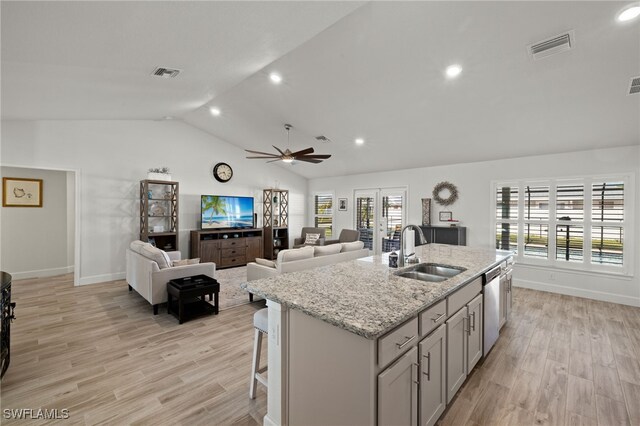 kitchen with ceiling fan, sink, stainless steel dishwasher, a kitchen island with sink, and light wood-type flooring