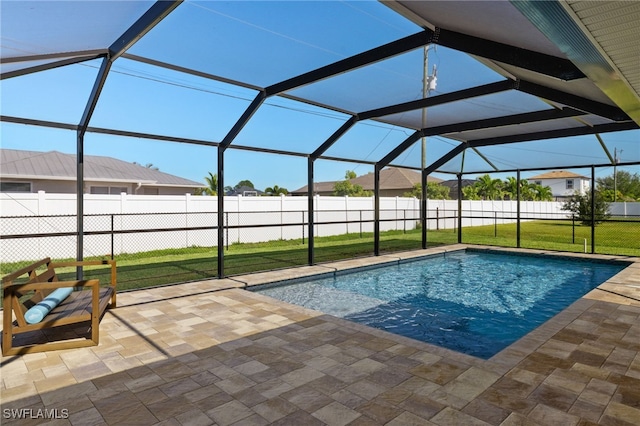 view of swimming pool featuring glass enclosure, a yard, and a patio