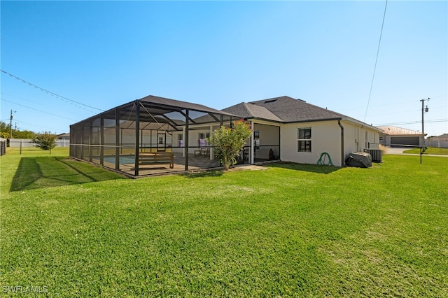 rear view of property featuring central AC, a lanai, a lawn, and a pool