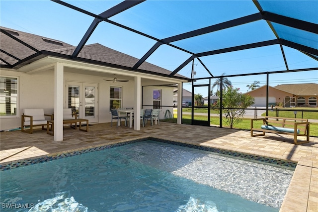 view of pool with glass enclosure, ceiling fan, french doors, and a patio