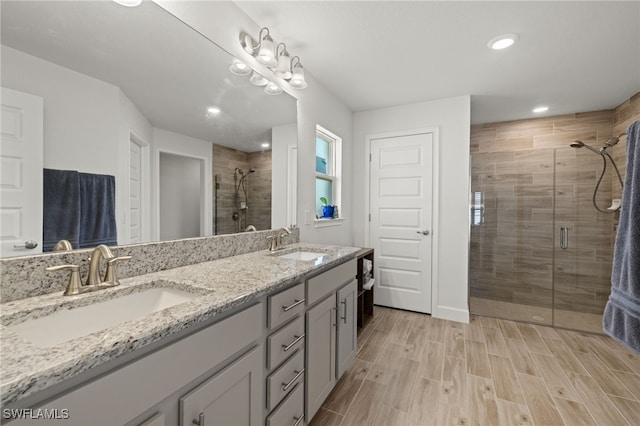 bathroom with hardwood / wood-style floors, vanity, and walk in shower