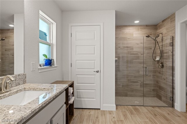 bathroom featuring vanity and a shower with shower door