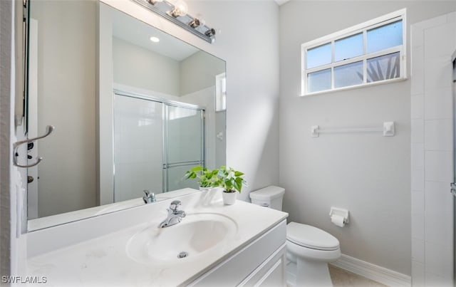 bathroom with tile patterned floors, vanity, toilet, and a shower with shower door