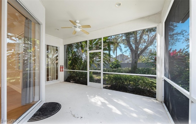 unfurnished sunroom with ceiling fan