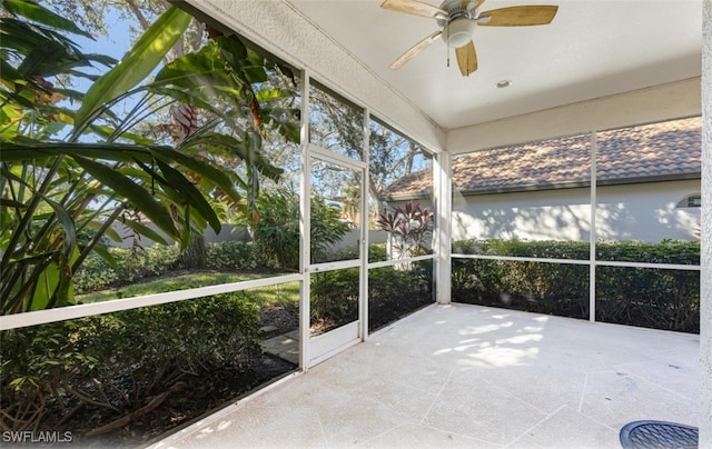 unfurnished sunroom with ceiling fan