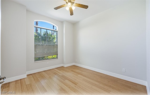 spare room with wood-type flooring, a wealth of natural light, and ceiling fan