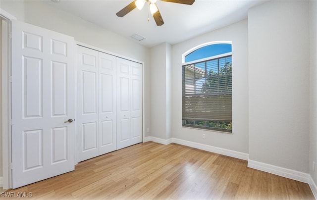 unfurnished bedroom featuring a closet, light hardwood / wood-style flooring, and ceiling fan