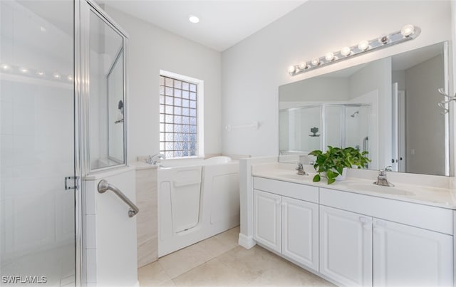 bathroom featuring tile patterned flooring, shower with separate bathtub, and vanity