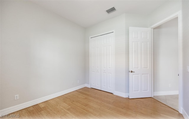 unfurnished bedroom featuring a closet and hardwood / wood-style floors