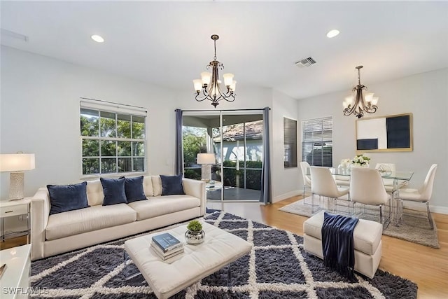 living room featuring light hardwood / wood-style flooring and an inviting chandelier