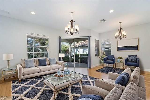 living room with light hardwood / wood-style flooring and a notable chandelier