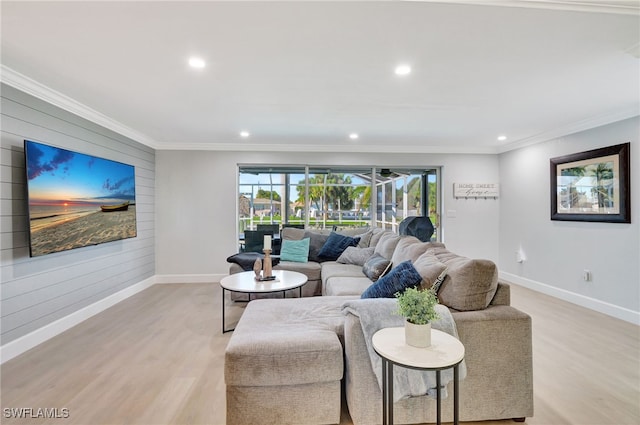 living room with light wood-type flooring, baseboards, crown molding, recessed lighting, and wood walls